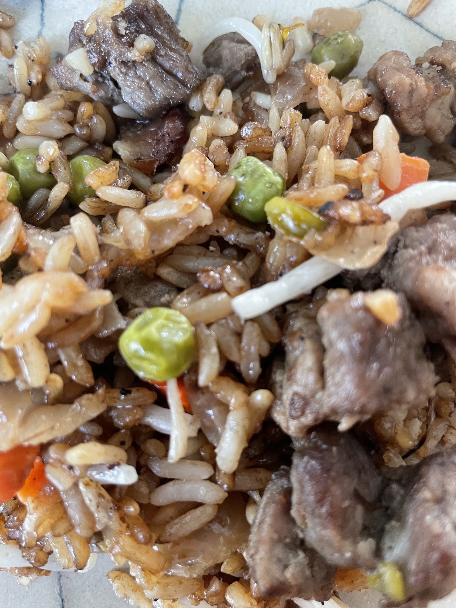Close up of beef fried rice with green peas, carrots and bean sprouts
