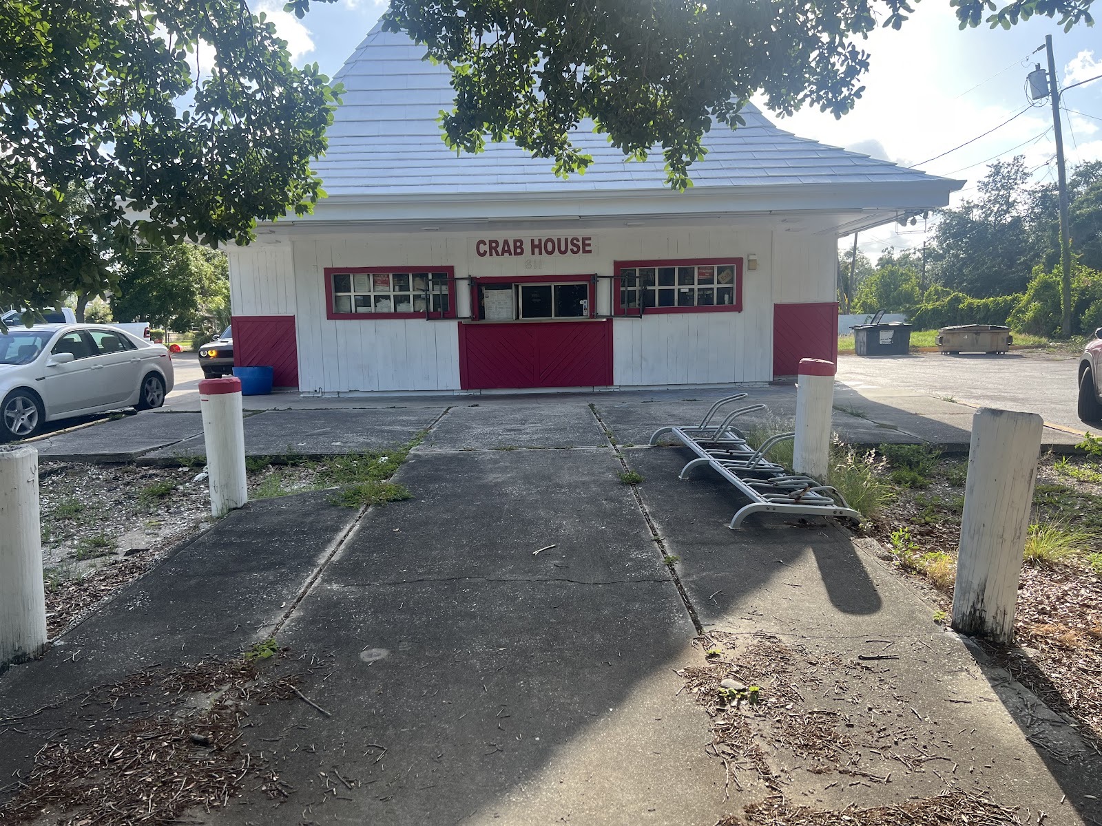 The Crab House building: a small white take-out shop with red trim, a peaked roof and Crab House lettered across the front
